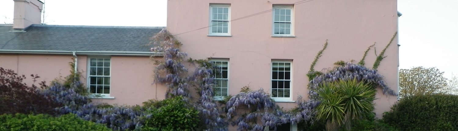 Pink Georgian building with Wisteria growing on the exterior