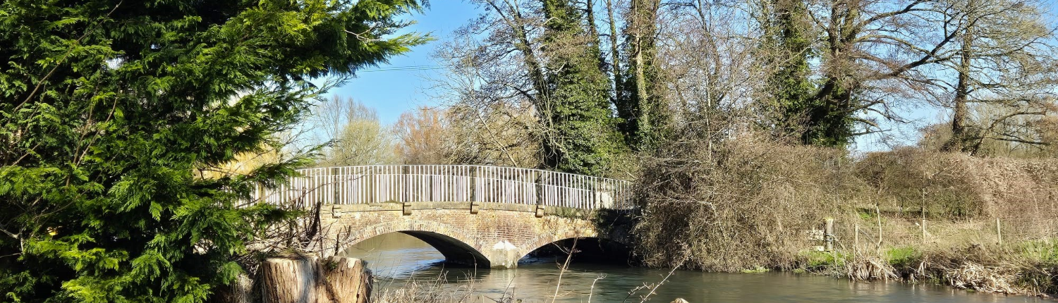 Woodford bridge over river and trees in the background